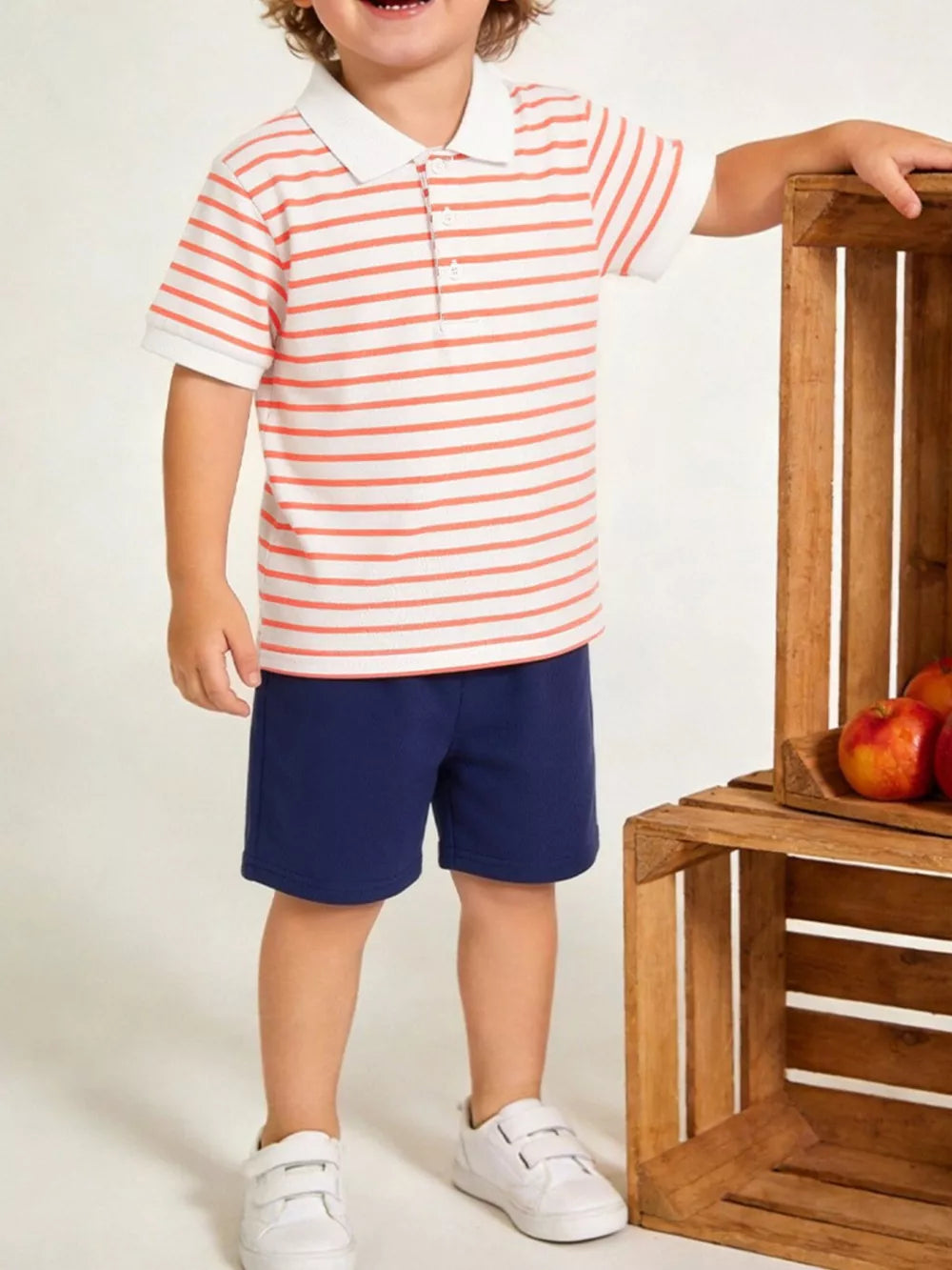 Baby boy's orange striped polo shirt and navy shorts set, comfortable cotton.
