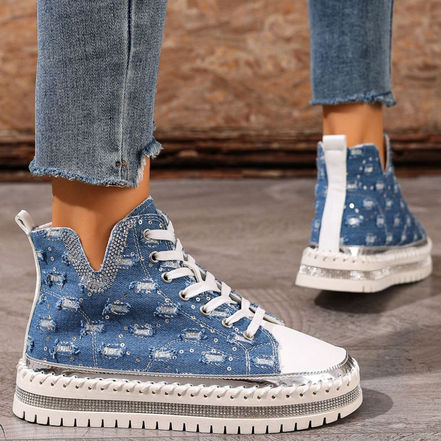 Blue denim high-top platform sneakers with white laces and rhinestone-embellished sole.