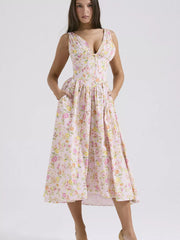 Floral print midi dress with V-neck and gathered bodice, in a light pink floral pattern.