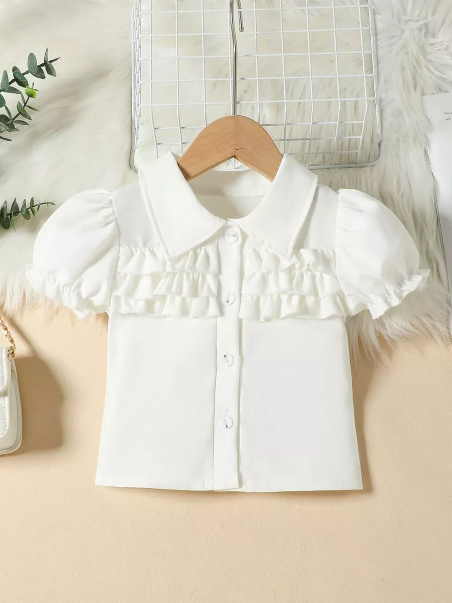 White baby top with puff sleeves, ruffled front, and button closure.