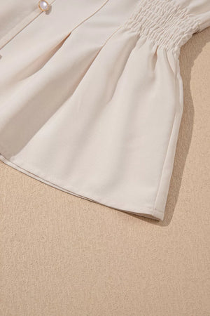 Elegant V-neck polyester blouse with smocked waist detail and pearl button.