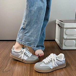 Silver and beige retro panelled lace-up trainers with white laces and a chunky sole.