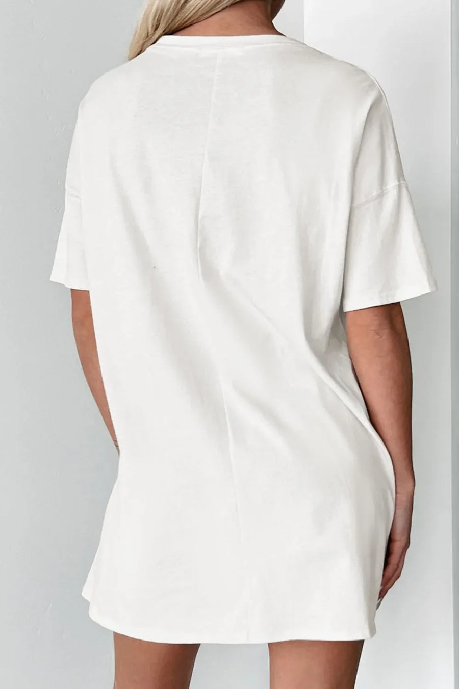 White oversized t-shirt dress with short sleeves and a relaxed fit.