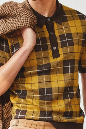 Checked knit polo with contrast trim in plaid, featuring a buttoned neckline and short sleeves.
