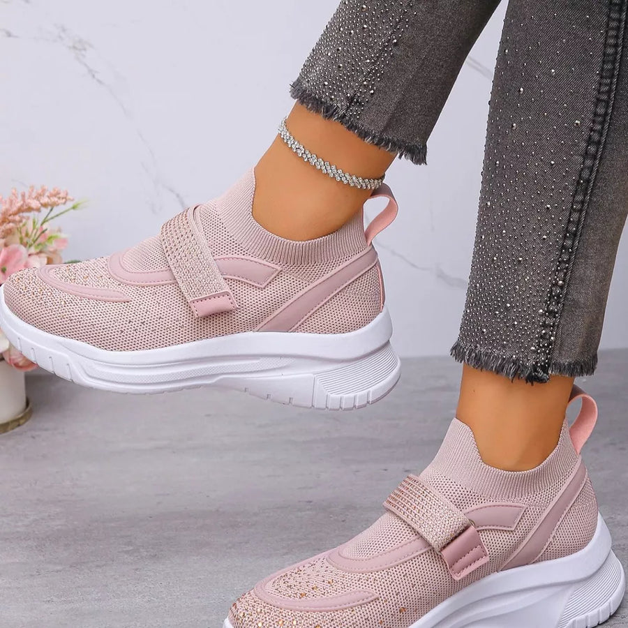 Pink mesh slip-on sneakers with adjustable strap and white sole.