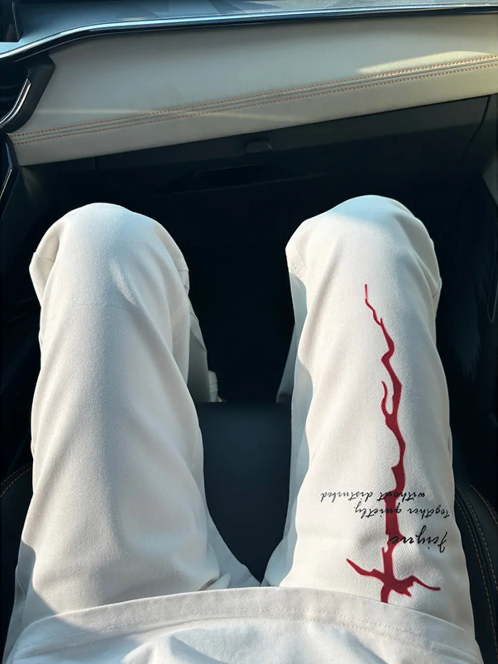Men's white sweatpants with red graphic print and text detail