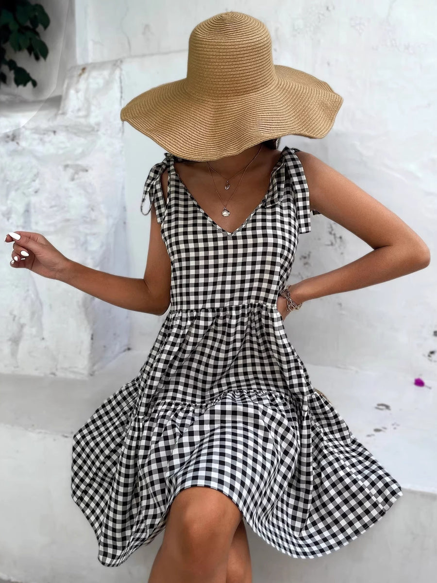 Black and white gingham tie-shoulder mini dress with tiered skirt.