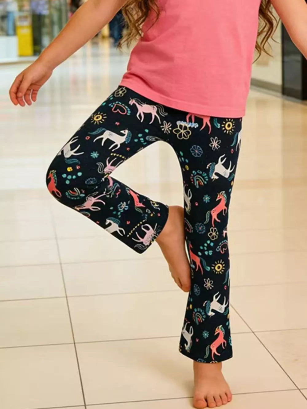 Toddler leggings with a dark navy background and a colorful unicorn and rainbow print.