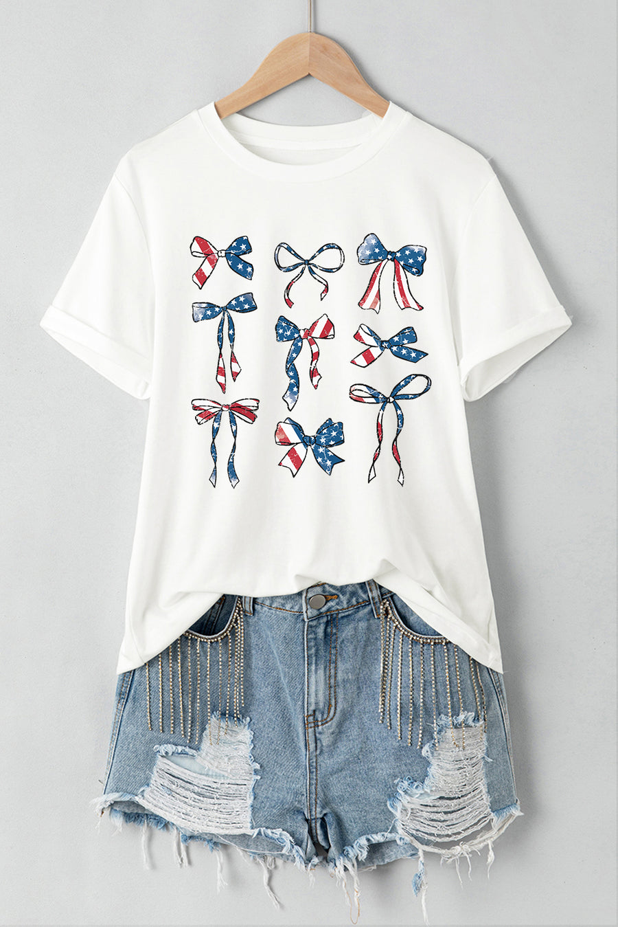 White t-shirt with a montage of patriotic bows in red, white, and blue flag print.