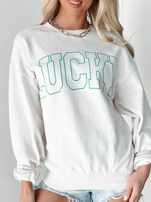White crewneck sweatshirt with green varsity "LUCKY" graphic and cuffed sleeves.