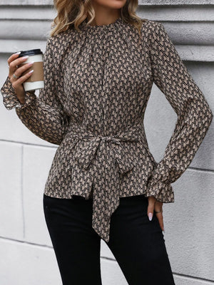 Tied ruffled flounce sleeve blouse in khaki with a geometric print and mock neckline.