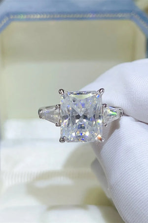 Silver ring with radiant cut moissanite center stone and two baguette side stones.