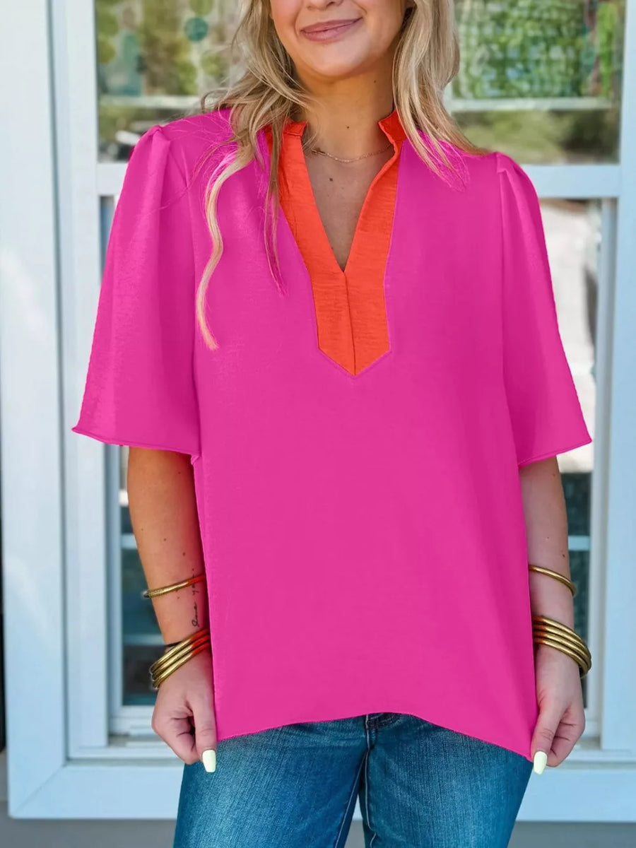 Textured pink blouse with orange V-neck detail and half sleeves.
