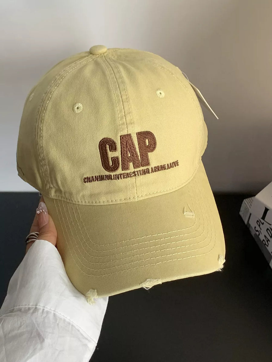 Yellow cotton baseball hat with distressed details and embroidered CAP text