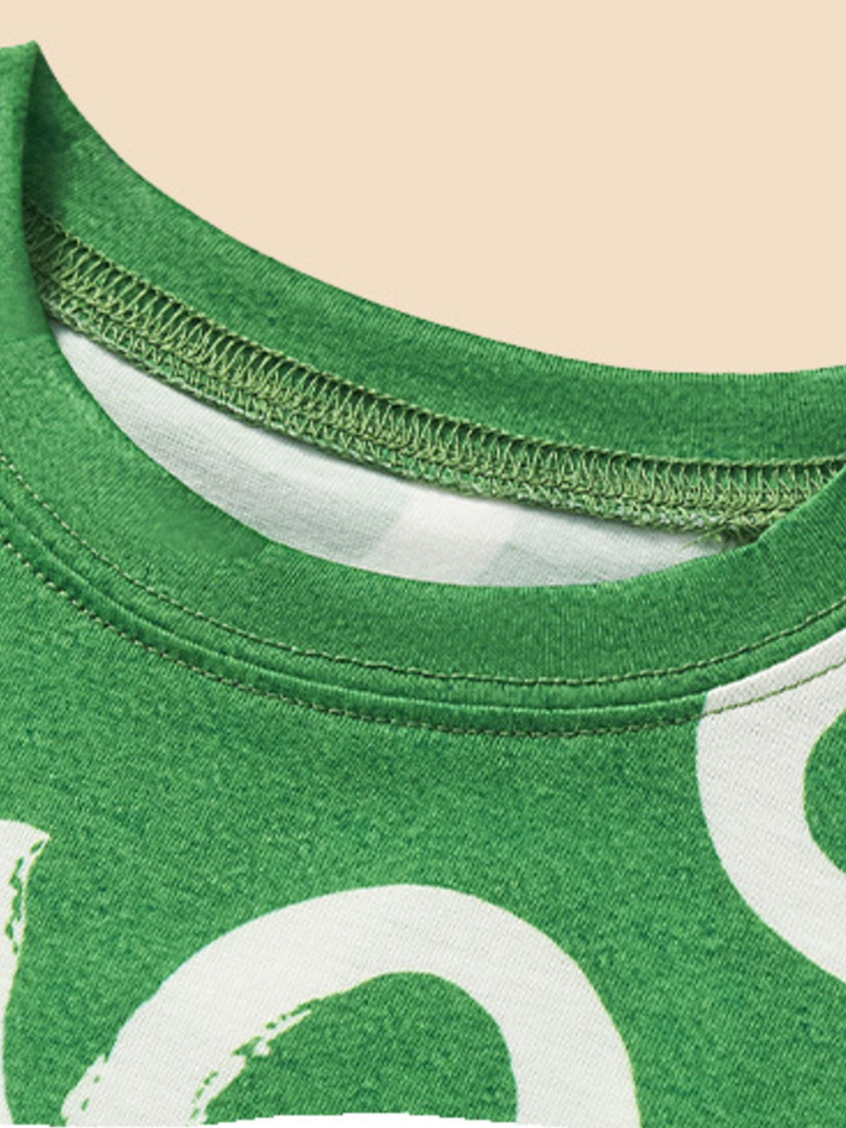 Green toddler crew neck tee with white clover print and reinforced stitching.