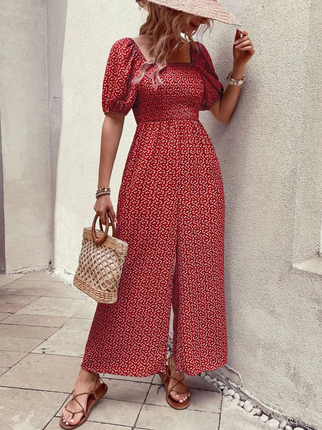 Red floral smocked bodice puff sleeve wide-leg jumpsuit with a square neckline and front slit.
