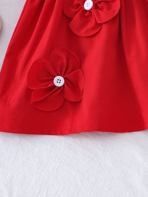 Red baby dress with flower appliqués and white buttons.