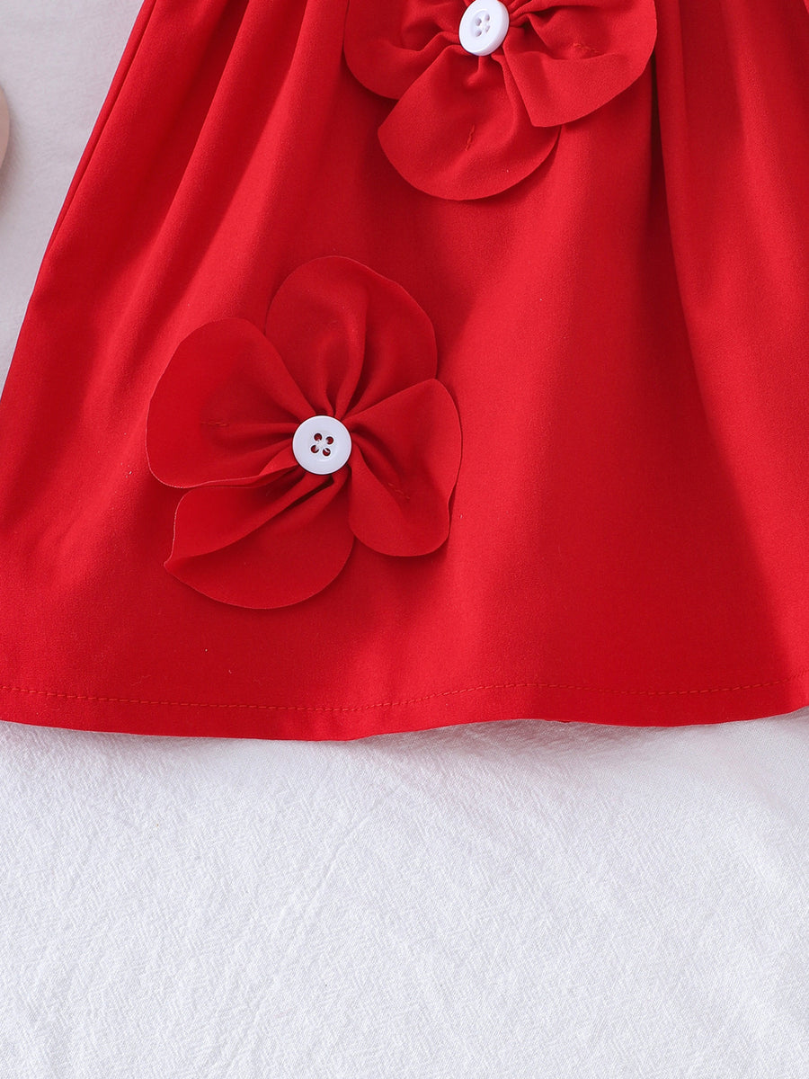 Red baby dress with flower appliqués and white buttons.