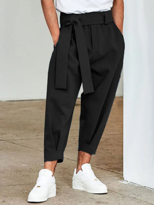 Black balloon-leg wrap trousers with a self-tie belt and cuffed hem.