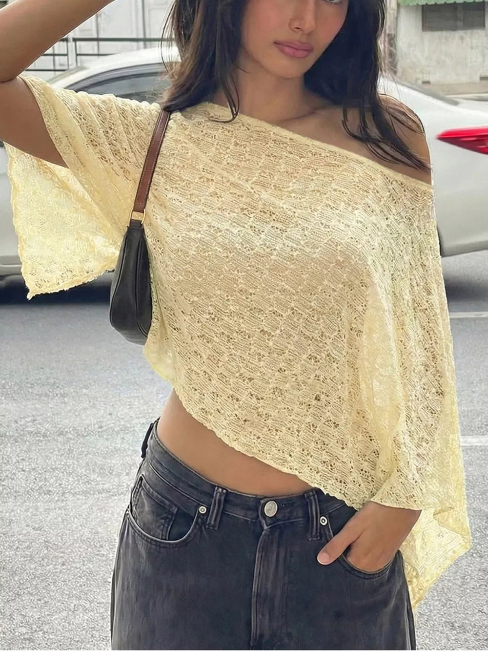 Yellow sheer one-shoulder cropped cardigan with a textured knit and wide sleeves.