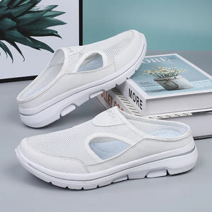 White sporty mesh cut-out mule slippers with breathable design and comfortable sole.