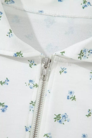 White zip-up top with a blue floral print and collar