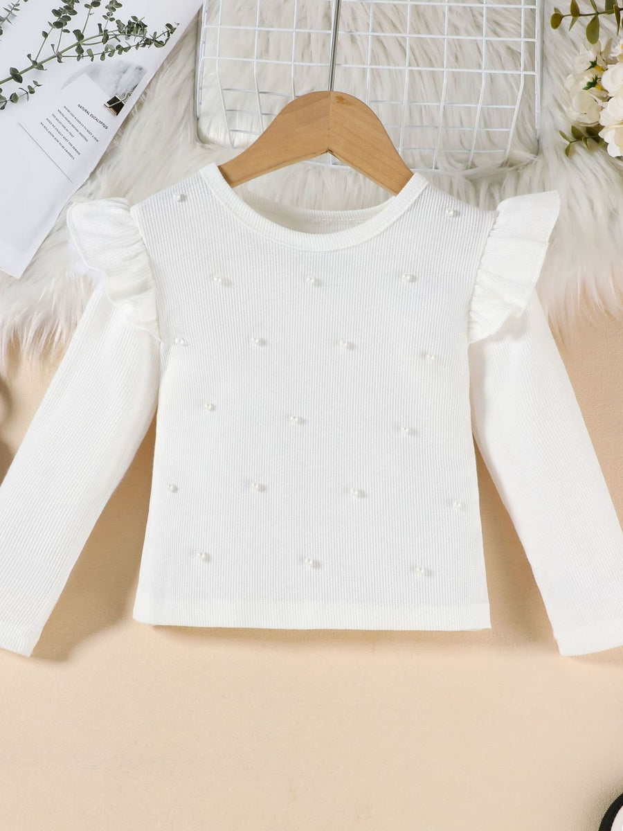 White toddler ruffle top with pearl embellishments and long sleeves.