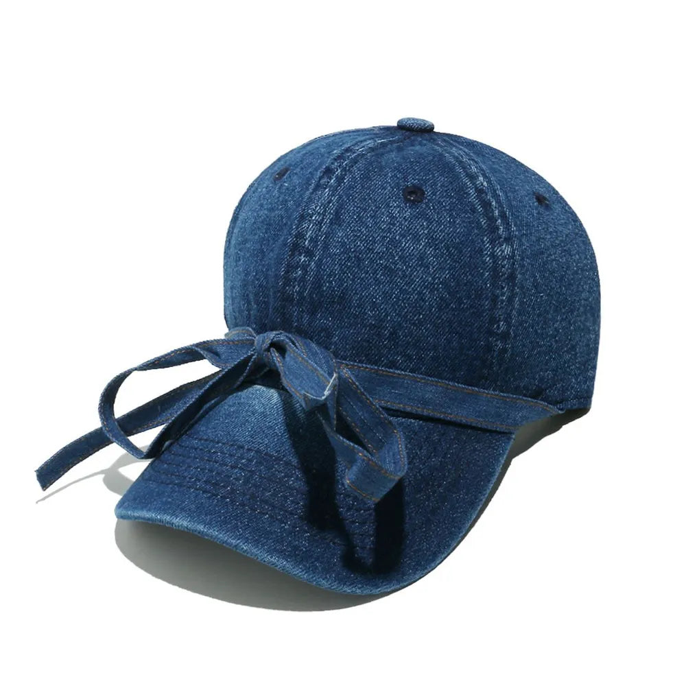 Denim baseball cap in navy with a decorative bow tie detail.