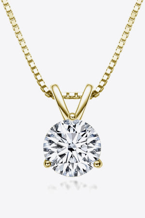 Gold box chain necklace with a round brilliant cut solitaire moissanite pendant.