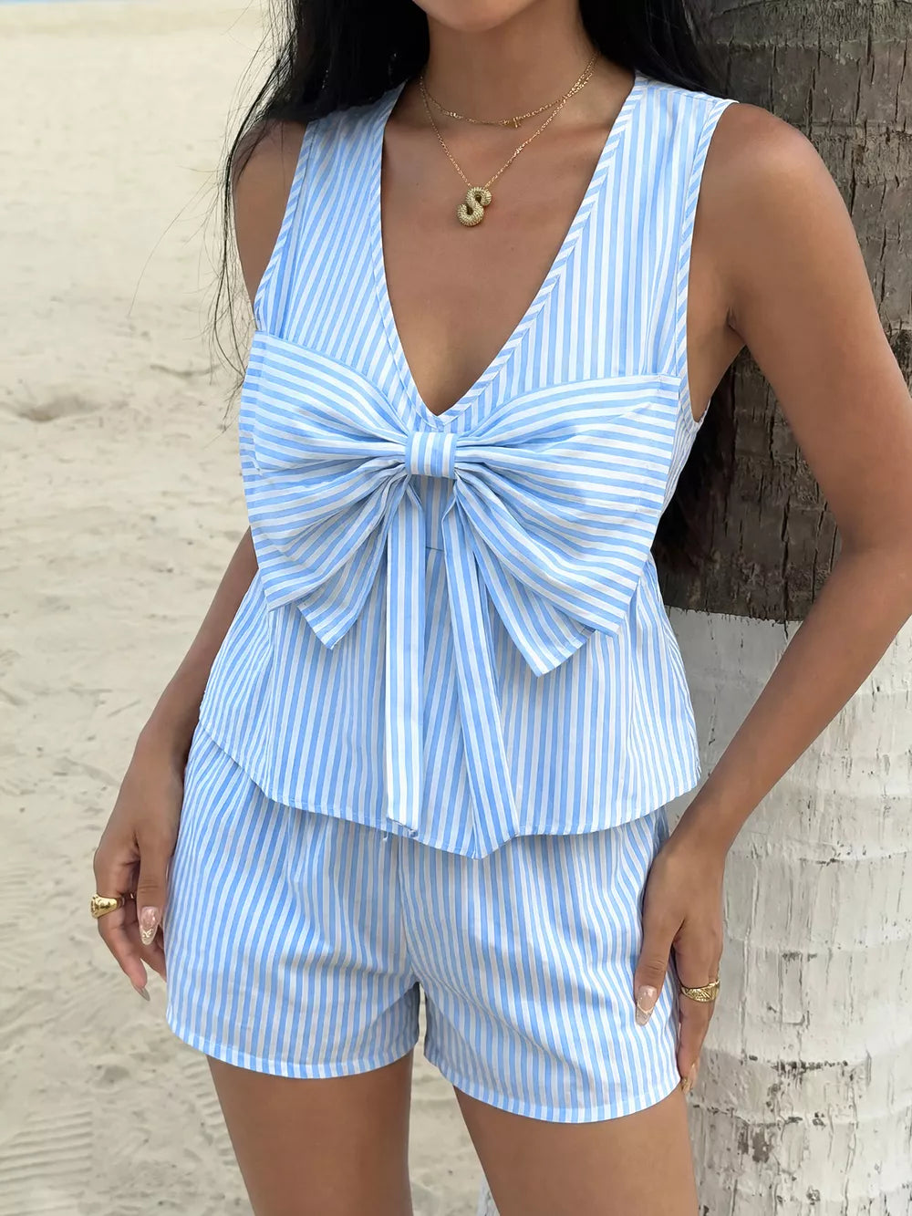 Blue and white striped two-piece set with a large bow detail on the V-neck top and matching shorts.