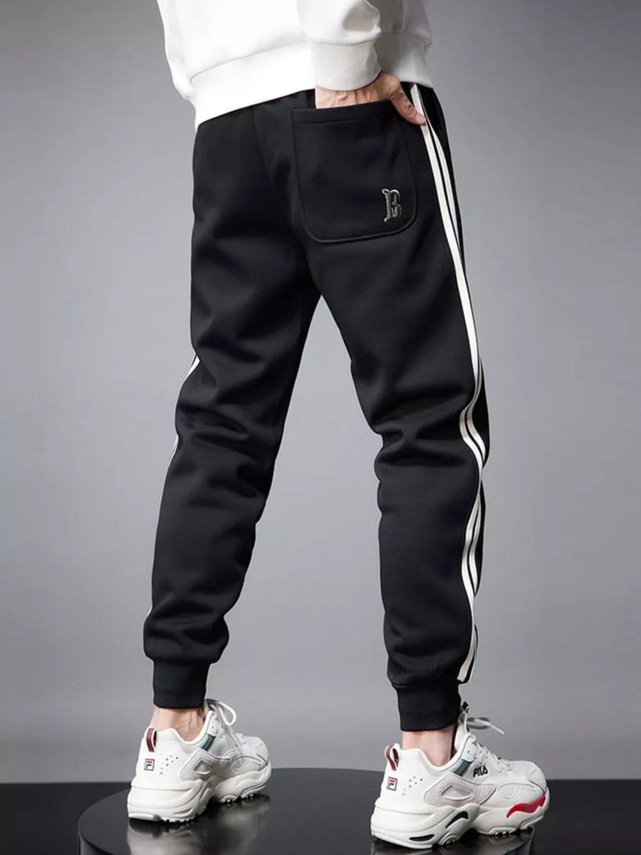 Black cotton joggers with white side stripes and a back pocket detail.