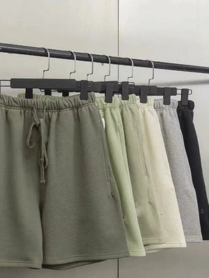 Men's jogger shorts in green, beige, gray, and black with drawstring waist