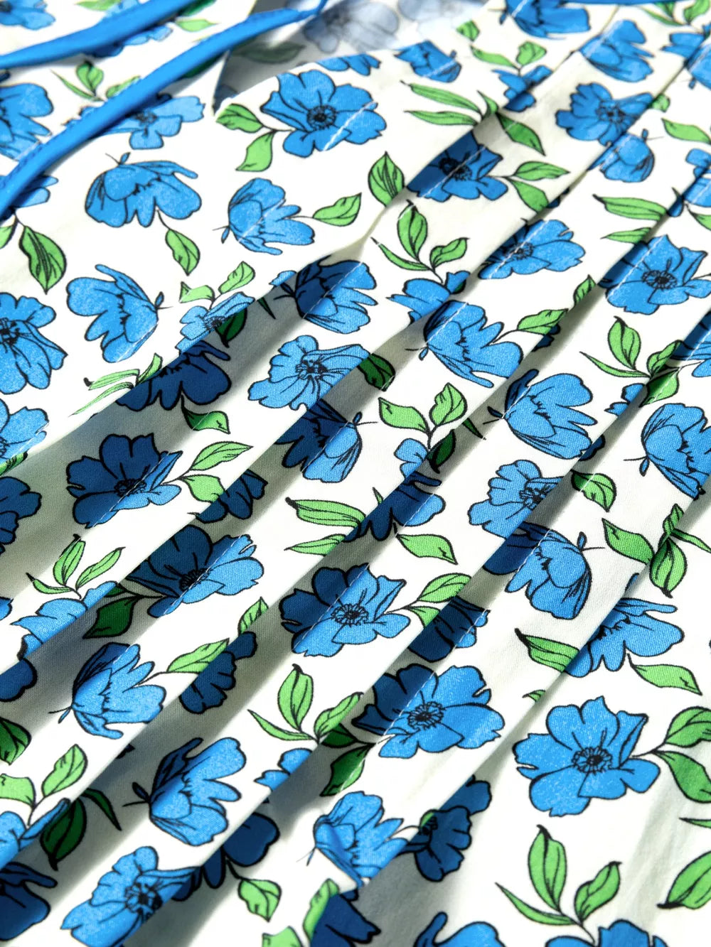 Floral ruffle sleeve tie-neck blouse with blue floral print on white cotton fabric.