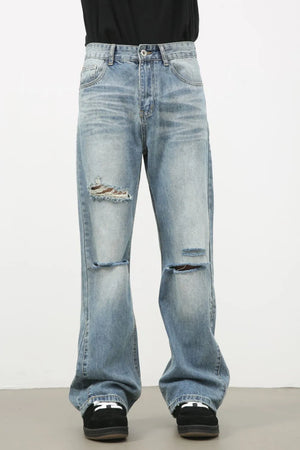 Distressed flare-leg denim jeans in medium wash with ripped details.