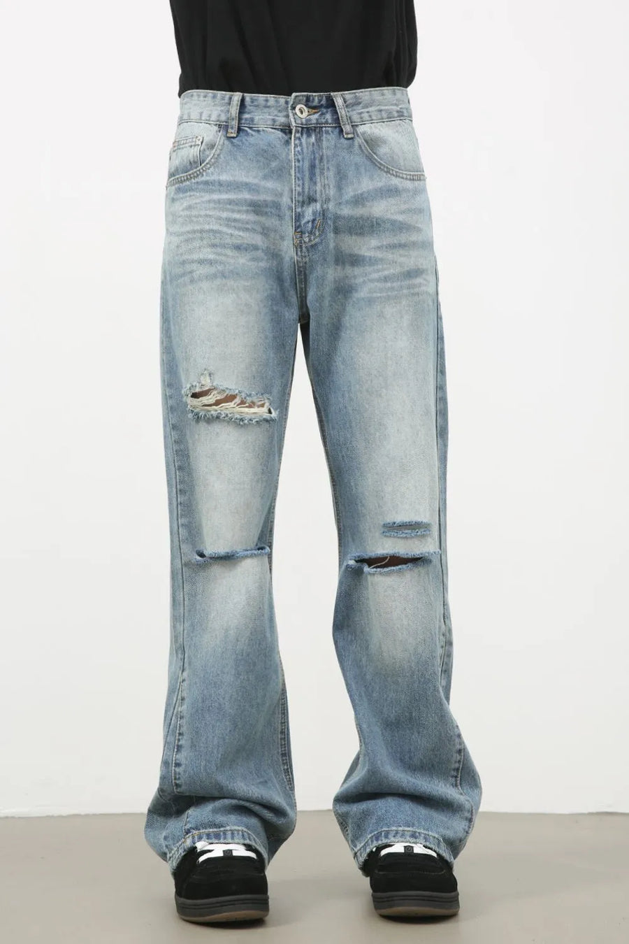 Distressed flare-leg denim jeans in medium wash with ripped details.