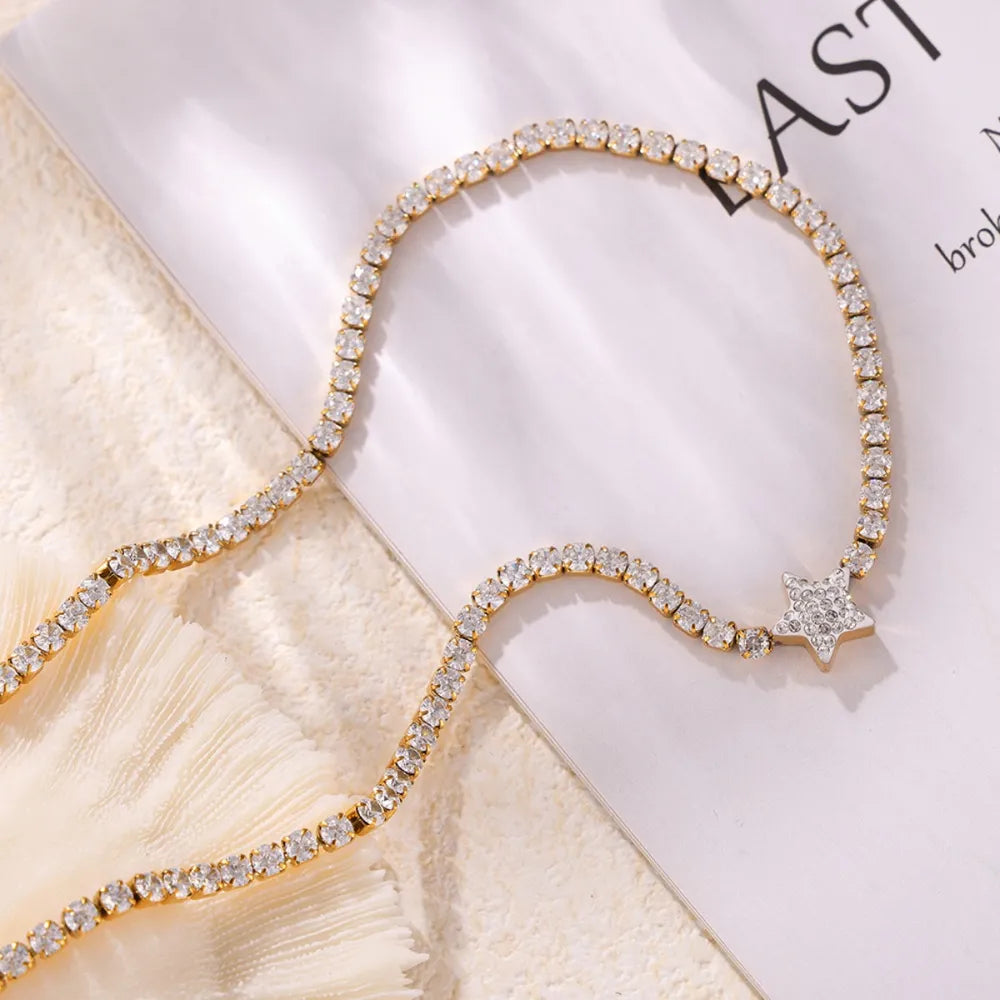 Gold choker necklace with pavé starburst detail and clear crystals