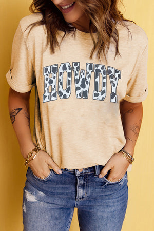 Light apricot t-shirt with cow print "Howdy" graphic and rolled sleeves.