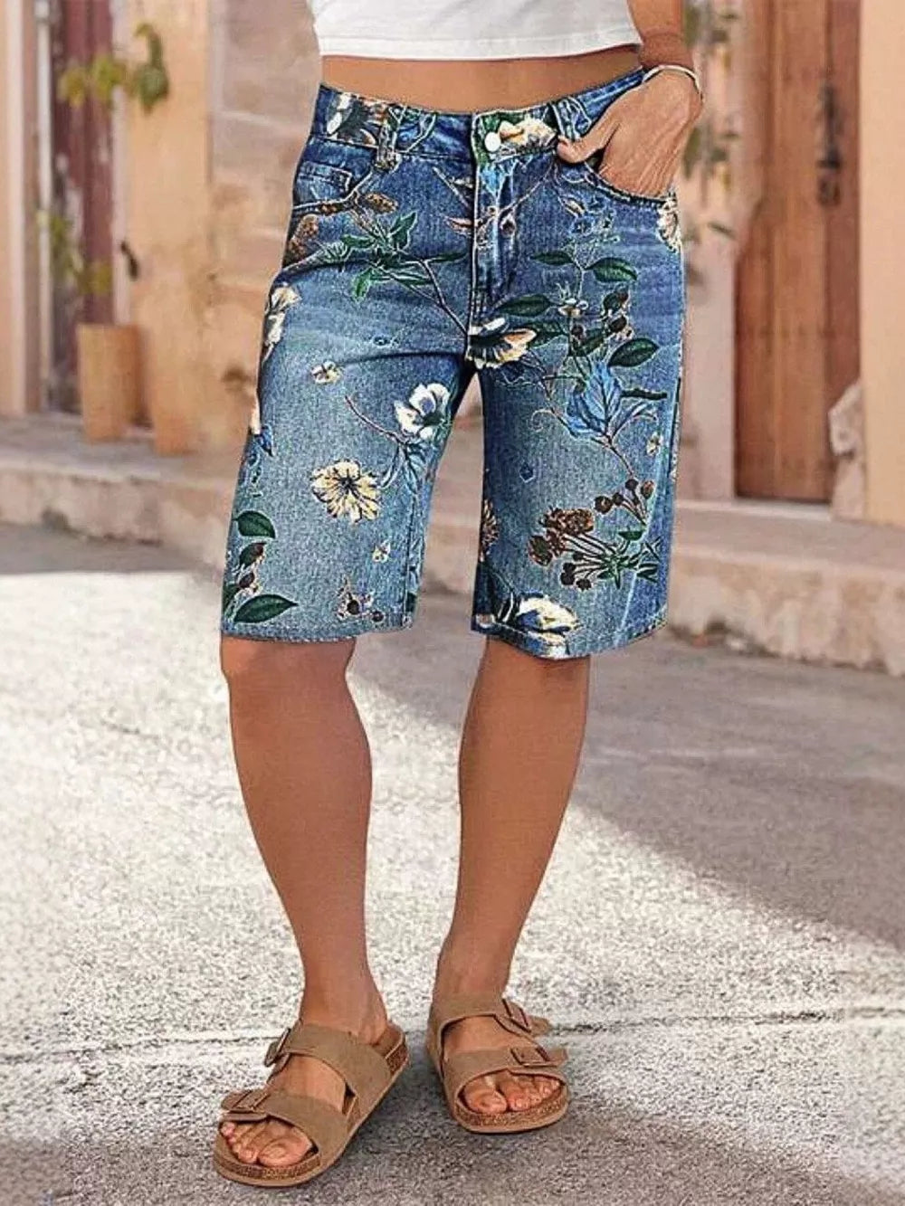 Blue botanical print relaxed fit denim shorts with a mid-rise waist and knee-length cut.