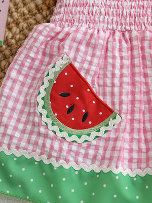 Smocked baby dress with pink gingham, watermelon pocket, and green polka dot trim.