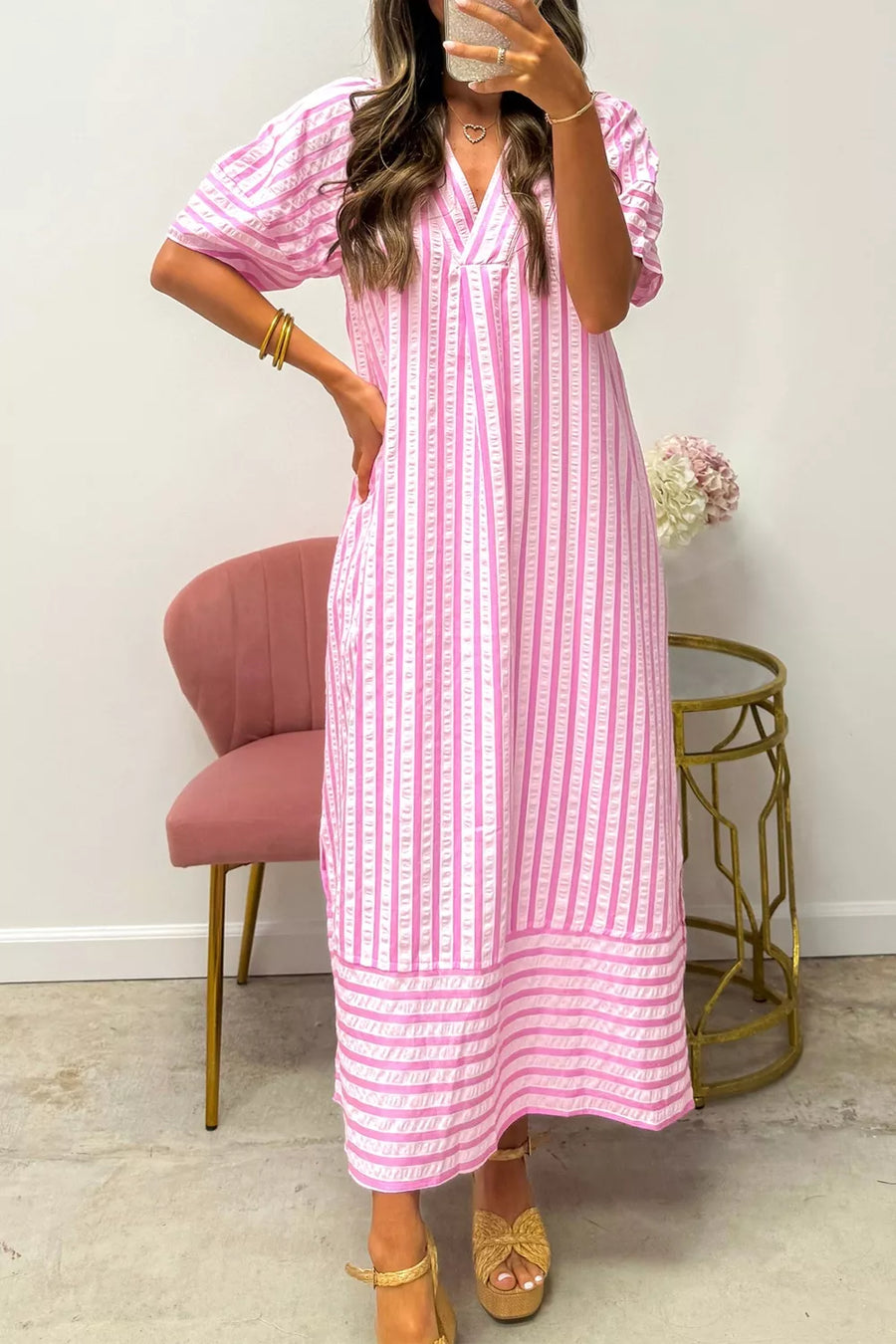 Pink striped midi dress with V-neck and short puff sleeves.