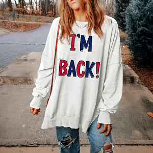 White graphic sweatshirt with I'M BACK! text, slit hem, and crew neck.