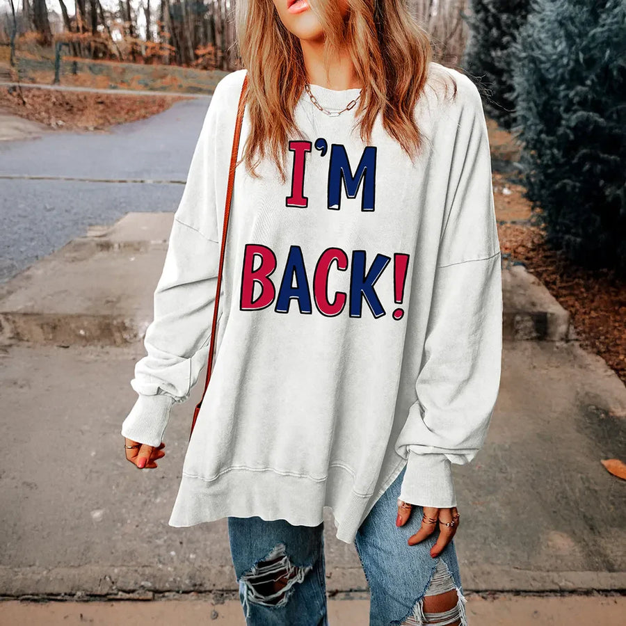 White graphic sweatshirt with I'M BACK! text, slit hem, and crew neck.
