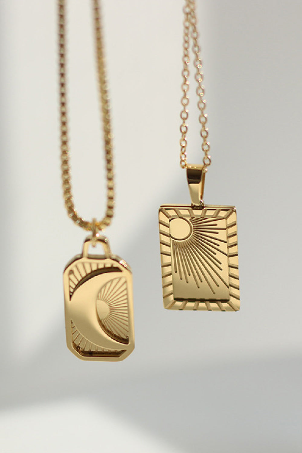 Celestial Charm pendant necklaces in Sun and Moon designs, 18K gold-plated.