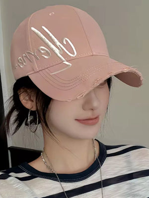 Pink distressed baseball cap with white embroidered script logo and frayed brim
