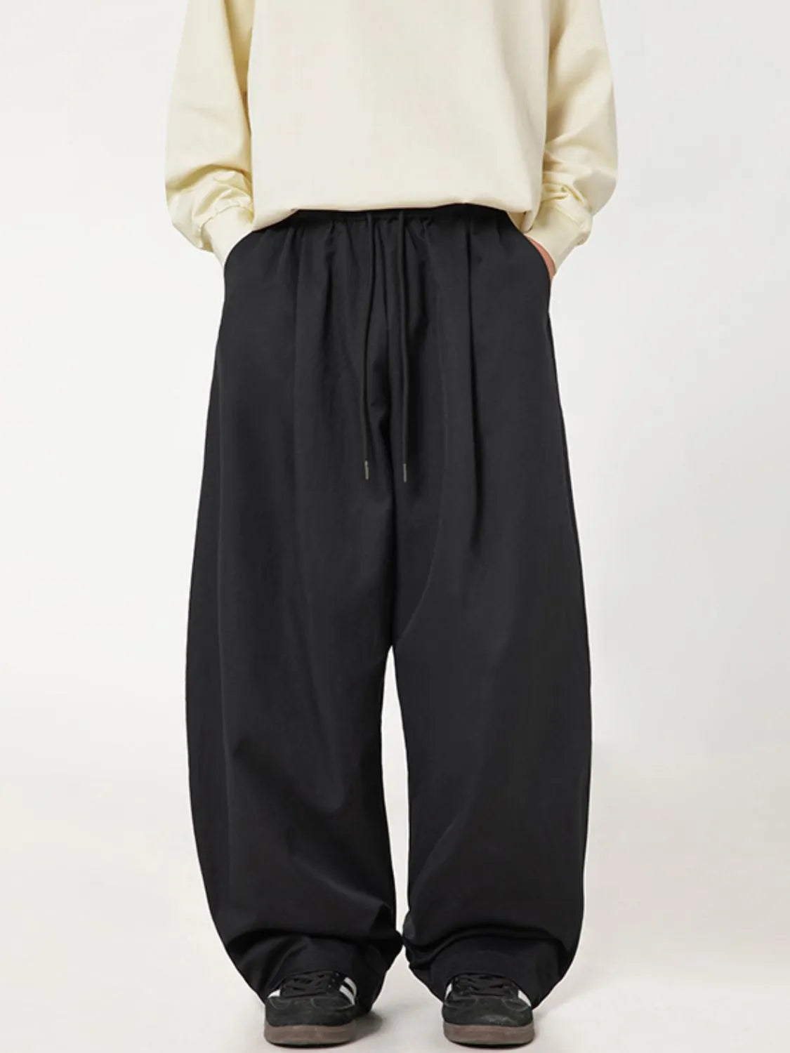 Black balloon-fit drawstring trousers with a casual, relaxed cut.