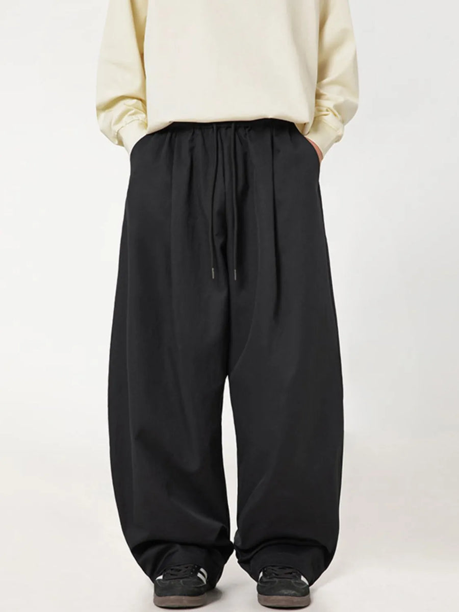 Black balloon-fit drawstring trousers with a casual, relaxed cut.