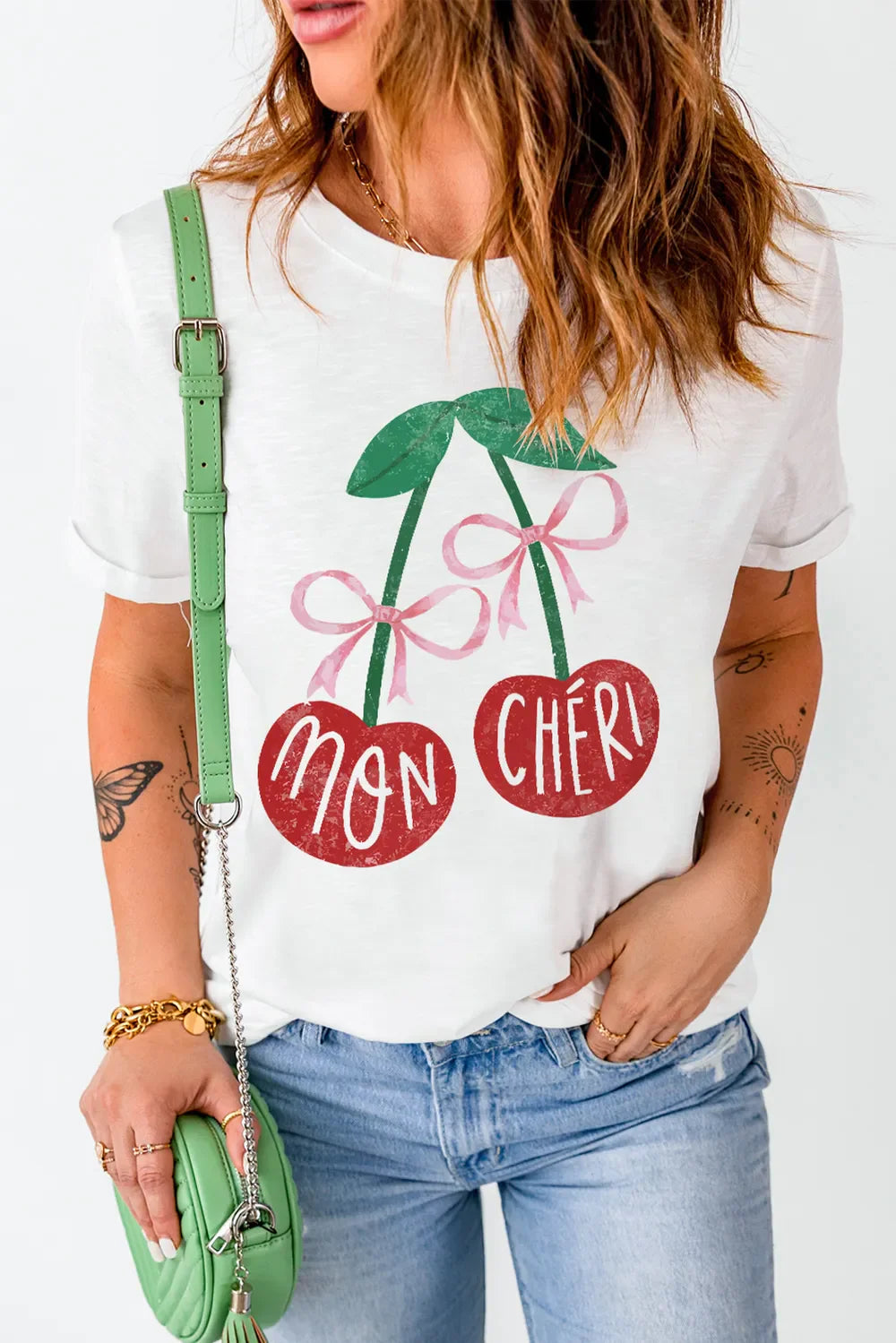 White graphic t-shirt with cherry print and "Mon Chéri" text, crew neck, short sleeves.