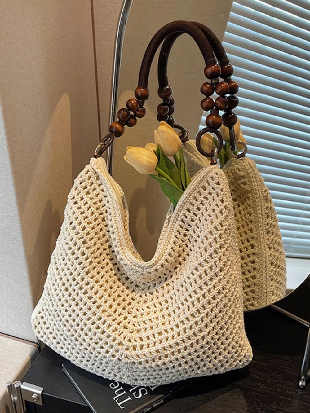 Ivory knit shoulder bag with open weave and beaded handle detail