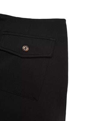 Black midi skirt with buttoned flap pocket and gold button detail.