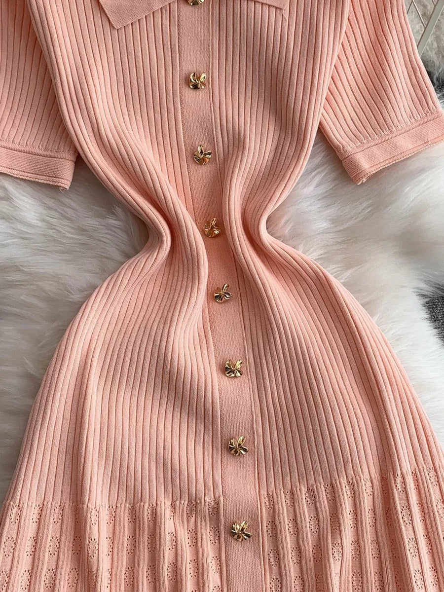 Pink ribbed knit midi dress with collar and gold bow buttons.